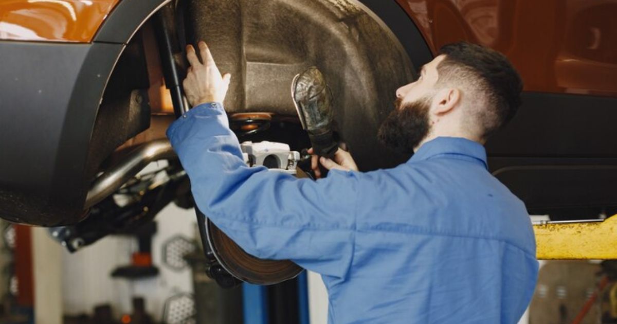 Technician inspecting a vehicle's braking system in an automotive workshop