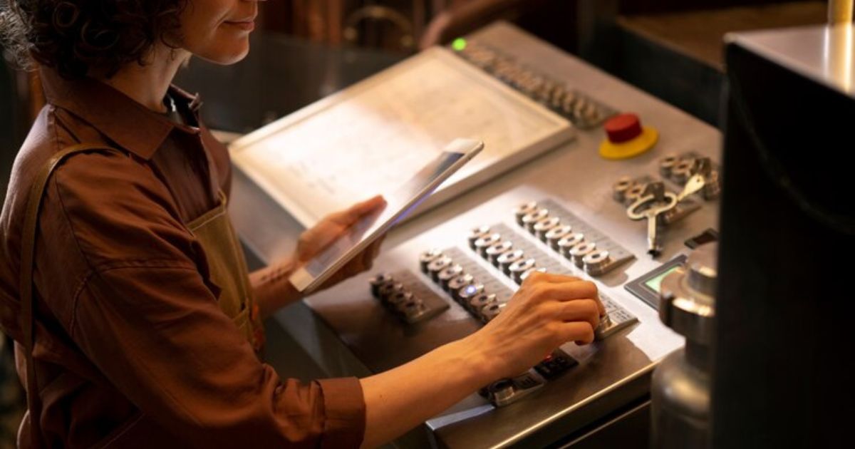 Engineer inspecting and configuring the Optima Series CNC Press Brake machine controls.